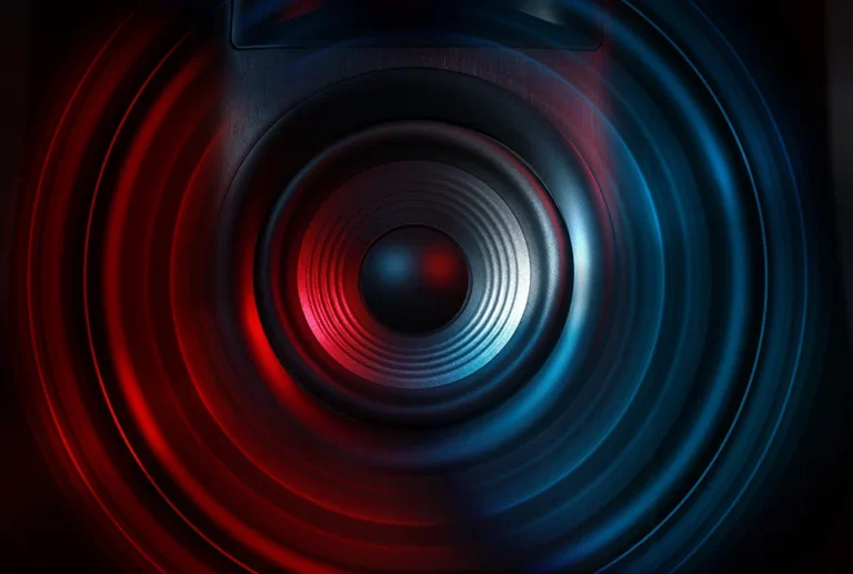 Close-up of a loudspeaker cone lit with red and blue hues, emphasizing concentric rings and texture.